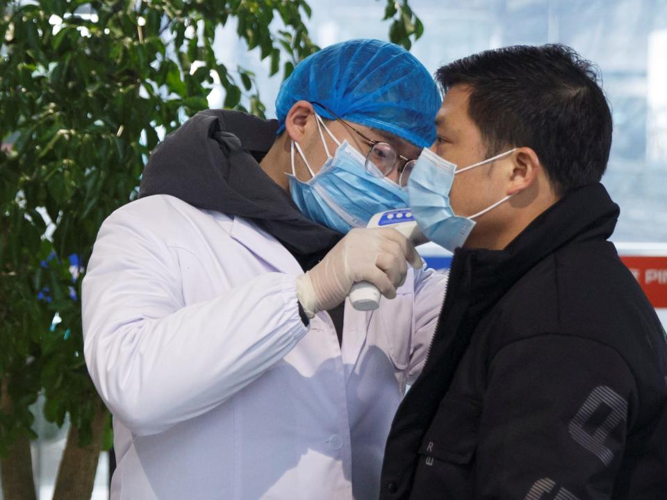 A medical official takes the body temperature of a child at the departure hall of the airport in Changsha, Hunan Province, as the country is hit by an outbreak of a new coronavirus, China, January 27, 2020.