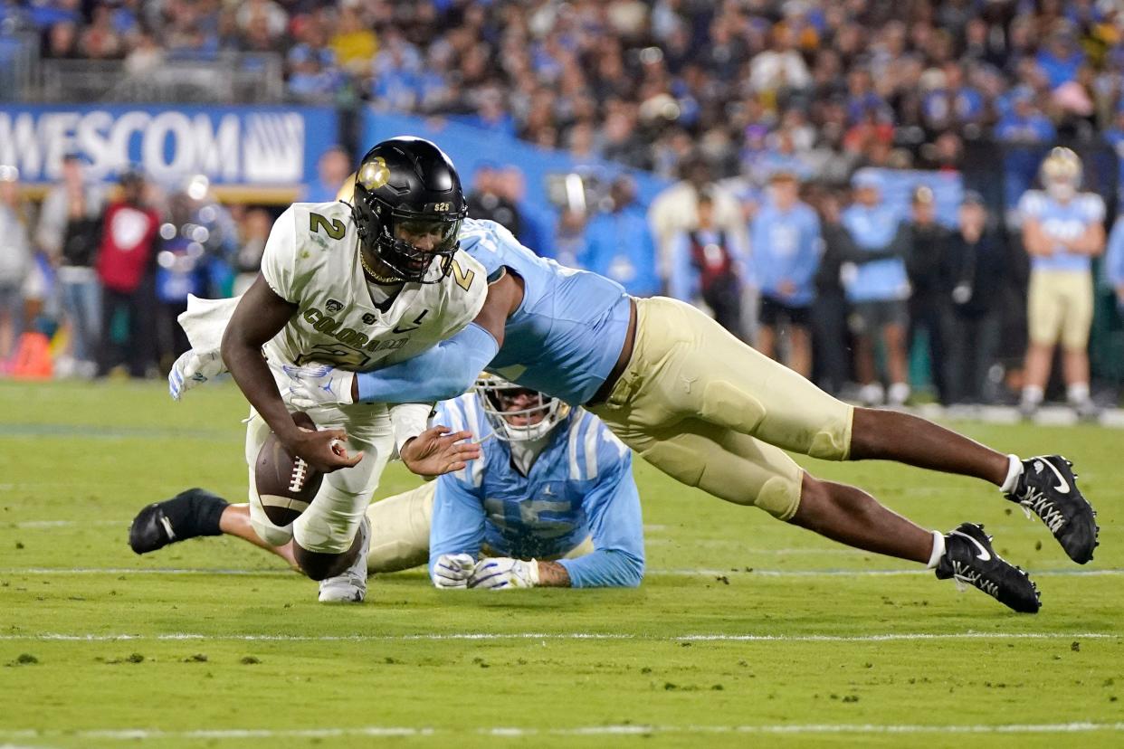 Colorado quarterback Shedeur Sanders, left, fumbles the ball as UCLA defensive lineman Gabriel Murphy, right, tackles him during the second half.