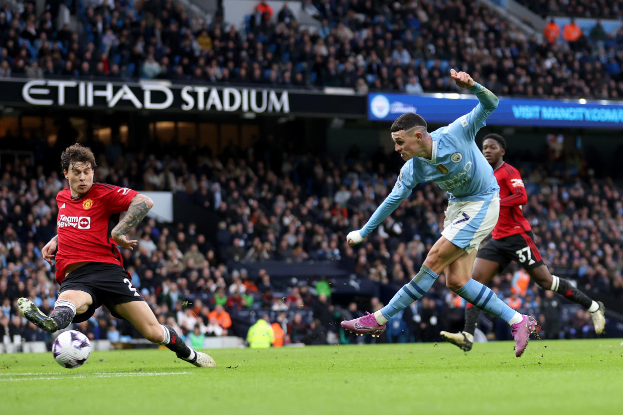 Manchester City forward Phil Foden scoring their second goal in their English Premier League match against Manchester United.