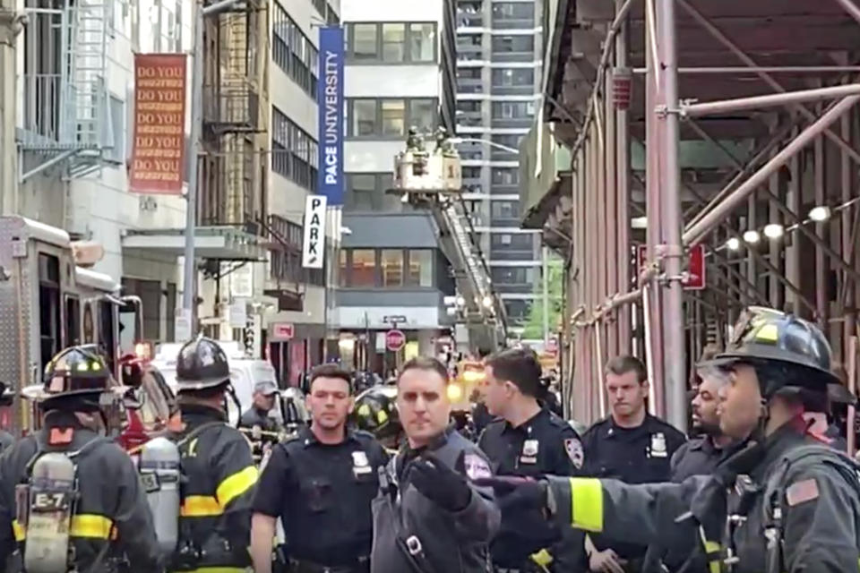 In this image taken from video, New York City Police and Fire Department personnel cordon off an area in New York's Financial District, Tuesday, April 18, 2023, near the site of a partially collapsed parking garage. It wasn't immediately clear whether anyone was injured. (AP Photo/Ted Shaffrey)