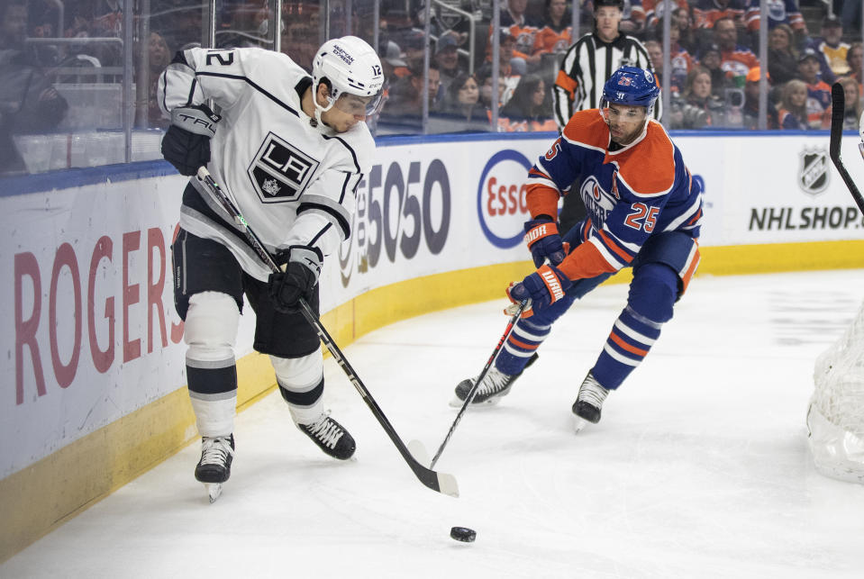 Los Angeles Kings' Trevor Moore (12) and Edmonton Oilers' Darnell Nurse (25) vie for the puck during the first period of an NHL hockey game Thursday, March 30, 2023, in Edmonton, Alberta. (Jason Franson/The Canadian Press via AP)