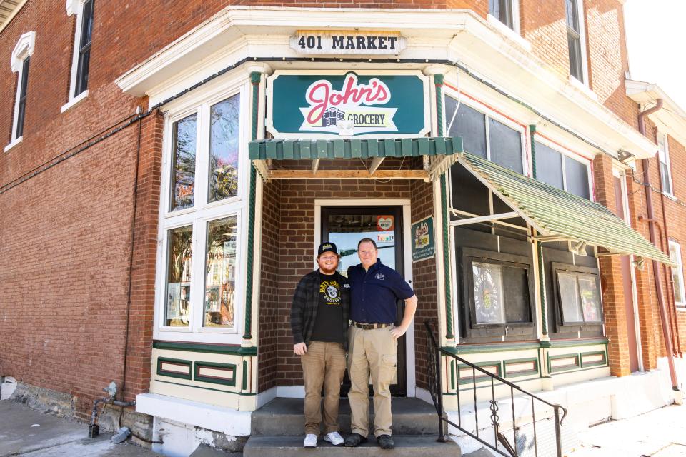 JD and Doug Alberhasky pose for a photo on the front steps of John's Grocery, Thursday, Nov. 9, 2023, at 401 Market Street in Iowa City, Iowa.