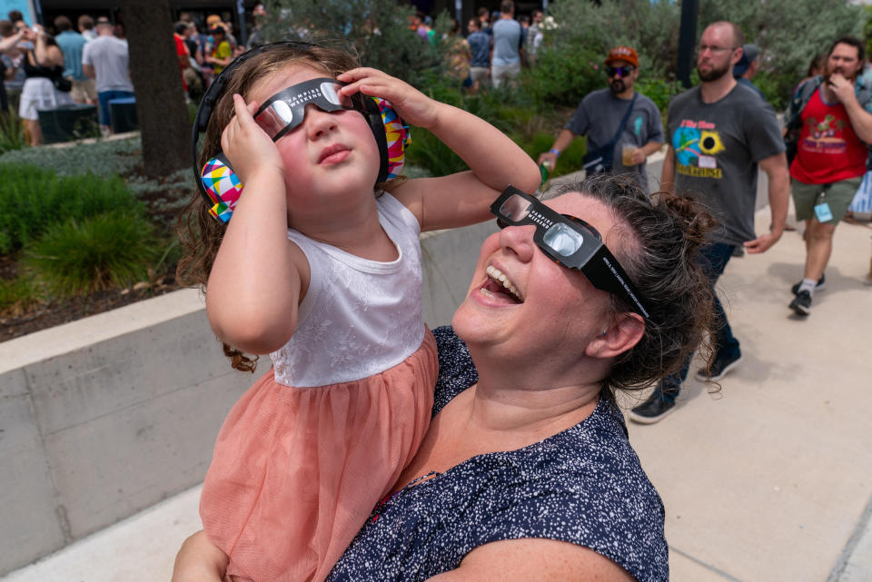 A mother and her daughter look up at the sun through protective eyewear during a solar eclipse in Austin, Texas, on April 8, 2024. / Credit: SUZANNE CORDEIRO/AFP via Getty Images
