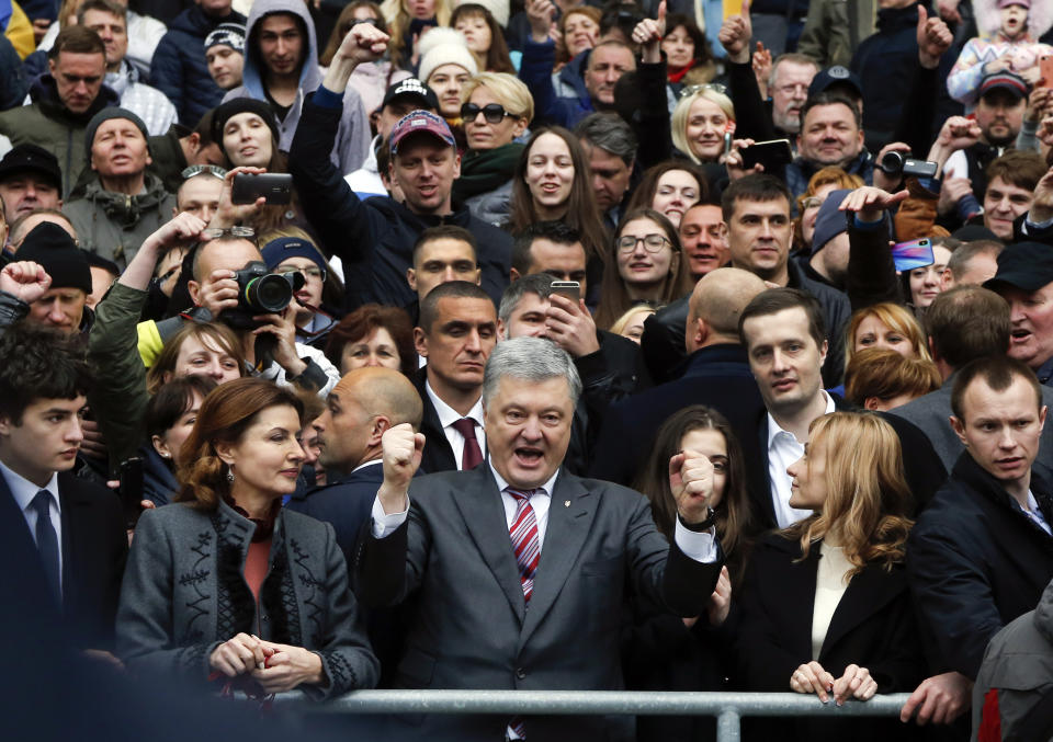 FILE - In this Sunday, April 14, 2019 file photo, Ukrainian President Petro Poroshenko, center, gestures as he poses for a photo with his supporters ahead of the presidential elections, at the Olympic stadium in Kiev, Ukraine. Ukraine’s presidential runoff on Sunday, April 21, is a battle between a billionaire tycoon who rode anti-Russian protests to the nation’s top office five years ago, and a comedian who plays a president in a TV sitcom. The actor has used humor and social media to take pole position. (AP Photo/Efrem Lukatsky, file)