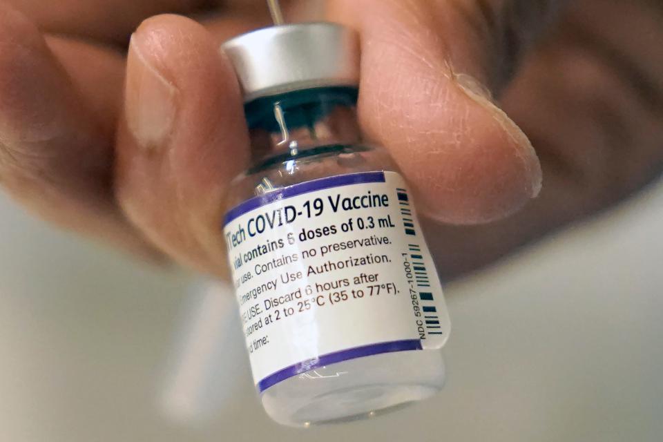 A doctor loads a dose of Pfizer COVID-19 vaccine into a syringe, Thursday, Dec. 2, 2021, at a mobile vaccination clinic in Worcester, Mass.