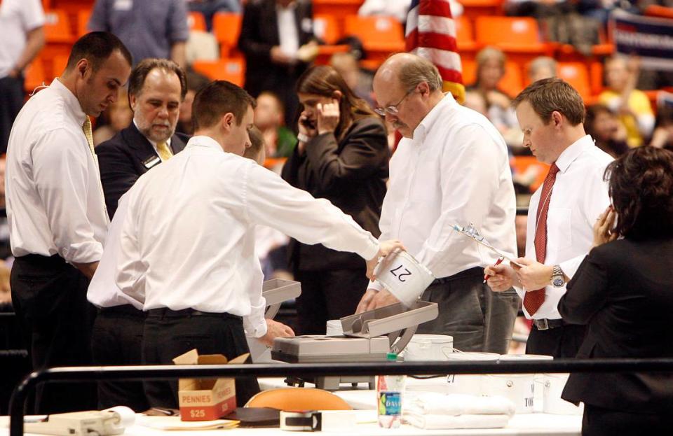 Officials empty buckets of coins, which were used to cast a vote, into coin counting machines at the Ada County Republican caucus on Super Tuesday March 6, at Taco Bell Arena on the campus of Boise State University to select a nominee for president. Photo by Joe Jaszewski