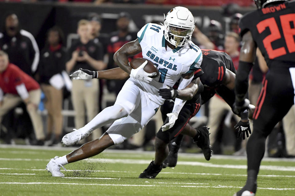 Coastal Carolina receiver Kameron Brown (11) is tackled by an Arkansas State defender during the first half of an NCAA college football game Thursday, Oct. 7, 2021, in Jonesboro, Ark. (AP Photo/Michael Woods)