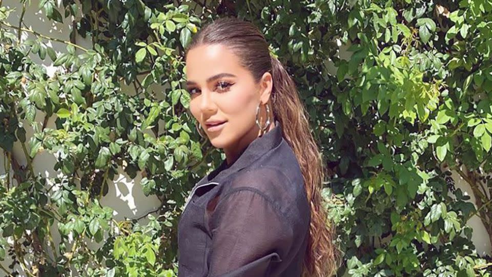 Khloe Kardashian wearing a black shirt and her hair in a ponytail