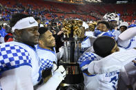 Kentucky players celebrate with The Governor's Cup following their victory over Louisville in an NCAA college football game in Louisville, Ky., Saturday, Nov. 27, 2021. (AP Photo/Timothy D. Easley)