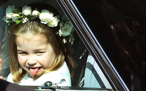 Princess Charlotte sticks out her tongue as she rides in a car to the wedding of Prince Harry and Ms Markle - Credit: Andrew Milligan/pool photo via AP