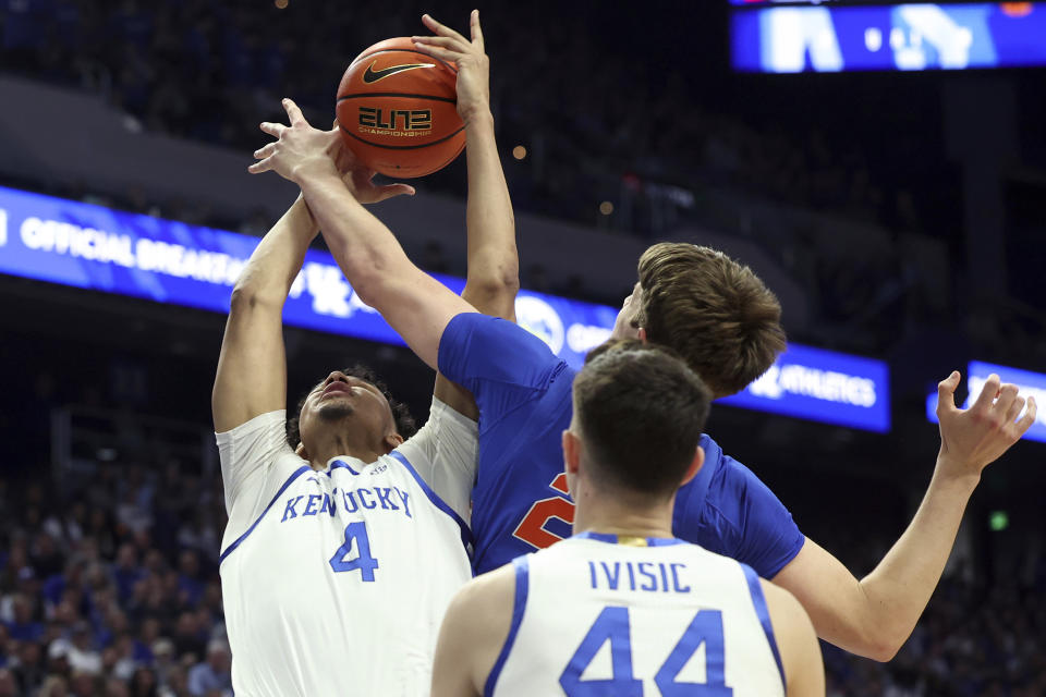 Kentucky's Tre Mitchell (4) shoots while pressured by Florida's Alex Condon, top right, during the first half of an NCAA college basketball game Wednesday, Jan. 31, 2024, in Lexington, Ky. (AP Photo/James Crisp)