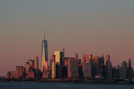 The setting sun is seen reflecting off 1 World Trade Center and other buildings in Manhattan in New York City, U.S., December 4, 2018. REUTERS/Brendan McDermid