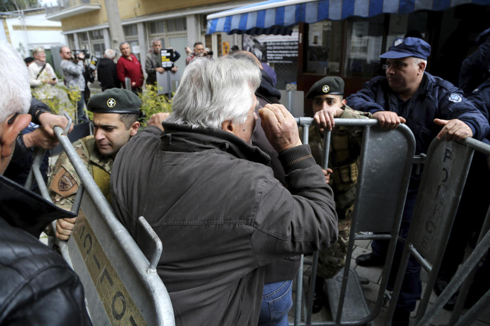 Protesters break the barriers as they demonstrate against the closing of a crossing point straddling a United Nations-controlled buffer zone in divided capital Nicosia, Cyprus, Saturday, Feb. 29, 2020. Around 200 people gathered at the Ledra Street crossing point to voice their opposition to its closing. The Cyprus government said it closed the Ledra Street crossing point along with three others to help with efforts to prevent the possible spread of a new COVID-19 virus either to the breakaway, Turkish Cypriot north or the internationally recognized, Greek Cypriot south. (AP Photo/Petros Karadjias)