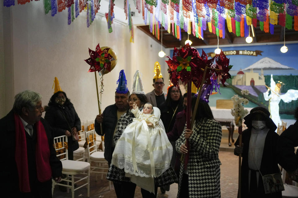 Residents participate in the procession of "Ninopan" during a Christmas "posada," which means lodging or shelter, in the Xochimilco borough of Mexico City, Wednesday, Dec. 21, 2022. For the past 400 years, residents have held posadas between Dec. 16 and 24, when they take statues of baby Jesus in procession to church for Mass to commemorate Mary and Joseph's cold and difficult journey from Nazareth to Bethlehem in search of shelter. (AP Photo/Eduardo Verdugo)