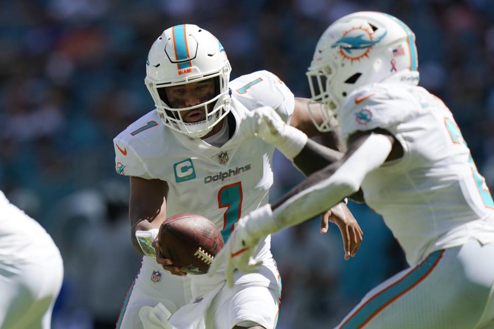 Miami Dolphins quarterback Tua Tagovailoa hands the ball.