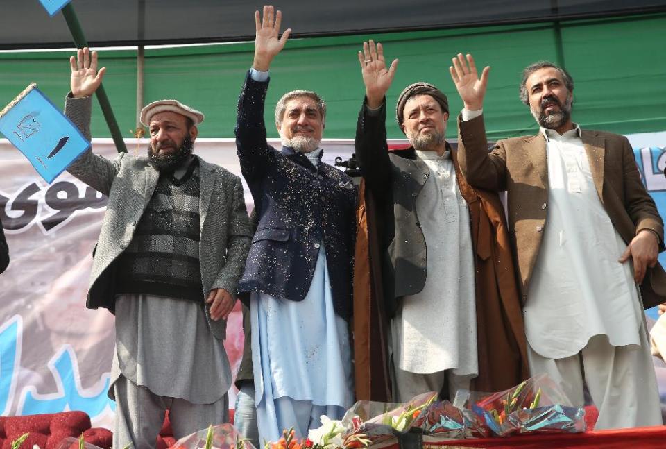 In this photo taken on Wednesday, March, 5, 2014, Afghan presidential candidate Abdullah Abdullah, second left, and his two vice presidential candidates wave to their supporters during a campaign rally in Deh Sabz district on the outskirts of Kabul, Afghanistan. (AP Photo/Massoud Hossaini)