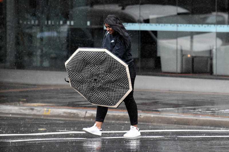 A pedestrian holds an umbrella during wet weather in Parramatta.