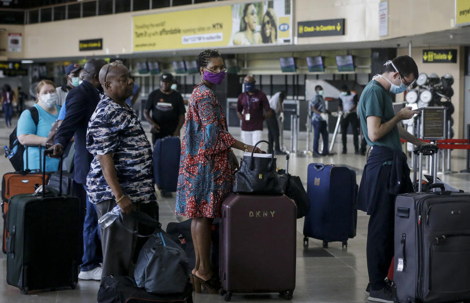 FILE - In this Tuesday, April 7, 2020 file photo, U.S. citizens queue to check in and be repatriated aboard an evacuation flight arranged by the U.S. embassy and chartered with Delta Air Lines, at the Murtala Mohammed International Airport in Lagos, Nigeria. African nations face a difficult choice as infections are rapidly rising: Welcome the international flights that originally brought COVID-19 to the ill-prepared continent, or further hurt their economies. (AP Photo/Sunday Alamba, File)