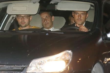 Former French President Nicolas Sarkozy (2ndL) arrives with police by car at the financial investigation unit in Paris to be presented to a judge late July 1, 2014. REUTERS/Pascal Rossignol