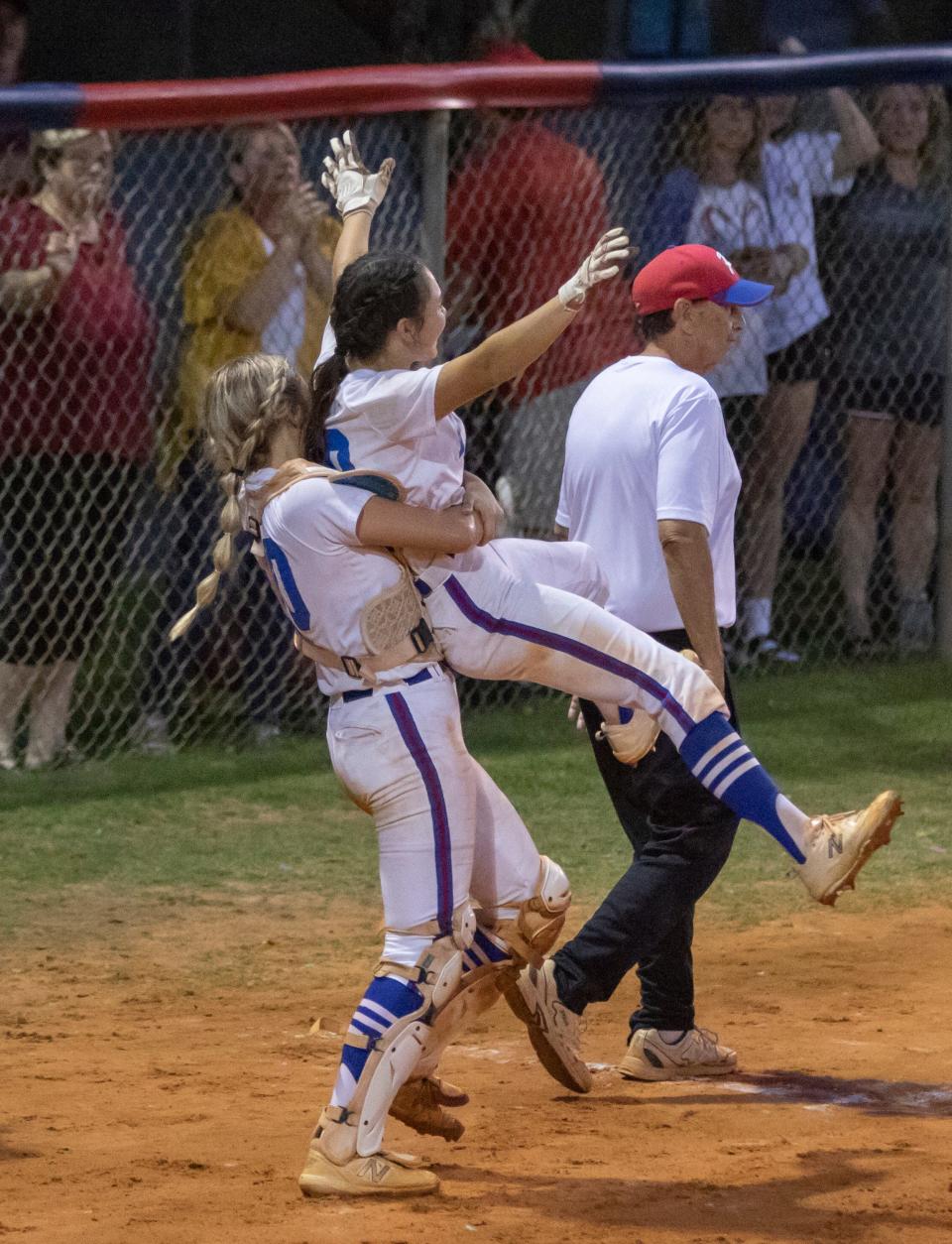 Mallory Baker (30) is congratulated on her 3-run walk-off home run over the left field wall in the bottom of the 6th inning during the University vs Pace 6A Regional Final playoff softball game at Pace High School on Friday, May 20, 2022.  The Patriots defeated the Titans 11-0 in the bottom of the 6th inning due to the mercy rule.