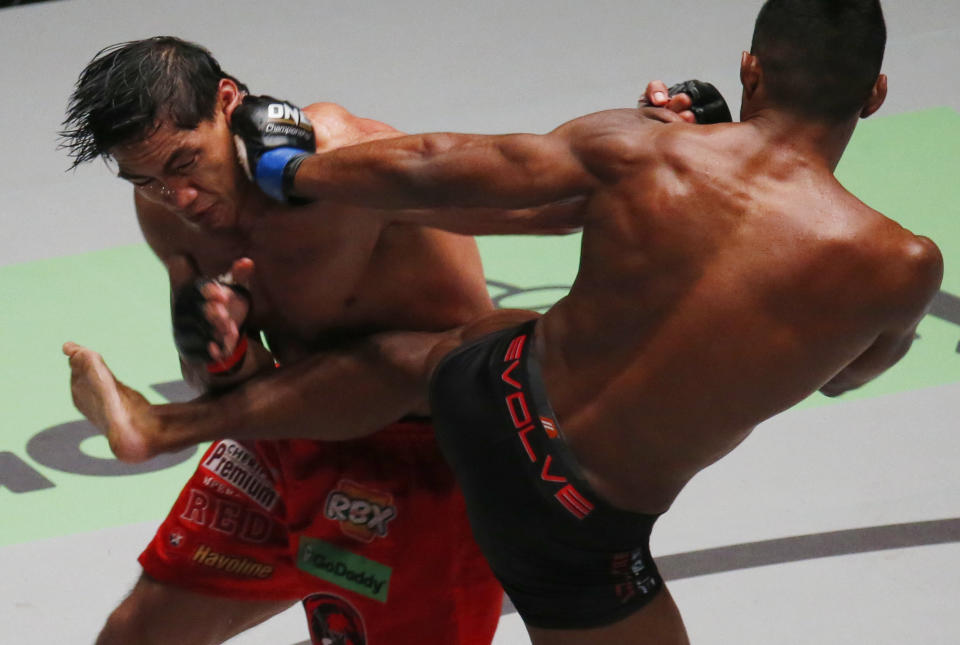 In this Friday, Nov. 23, 2018, file photo, Singapore's Amir Khan, right, lands a kick and a knee to the Philippines' Eduard Folayang during their Lightweight ONE Championship mixed Martial Arts bout at the Mall of Asia Arena in suburban Pasay city south of Manila, Philippine. Folayang won over Amir Khan via a unanimous decision to win the vacant title. The victory of Folayang garnered five championship belts for the Philippines in the world sports of mixed martial arts. (AP Photo/Bullit Marquez, File)