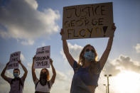 Protesters hold signs and shout slogans during a protest to decry the killing of George Floyd in front of the American embassy in Tel Aviv, Israel, Tuesday, June 2, 2020. (AP Photo/Ariel Schalit)