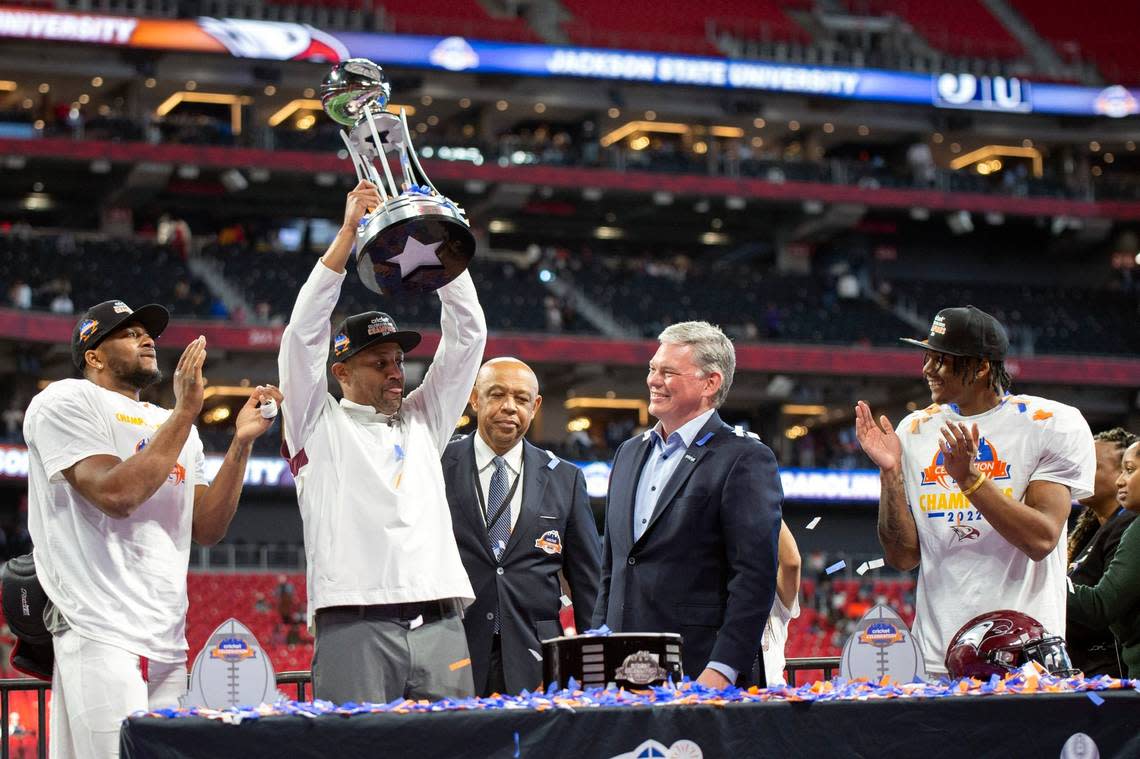 North Carolina Central quarterback Davius Richard and defensive back Khalil Baker clap and cheer as head coach Trei Oliver raises the championship trophy after the Celebration Bowl NCAA college football game against Jackson State, Saturday, Dec. 17, 2022, in Atlanta. (AP Photo/Hakim Wright Sr. )