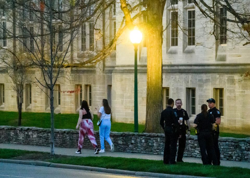 Police officers stand along Indiana Avenue during Saturday night as they prepare to deal with crowds of people visiting nearby bars during Little 500 weekend.