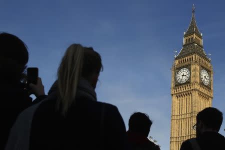 People are silhouetted against the sky as the pass the Big Ben bell tower at the Houses of Parliament in London, Britain February 22, 2016. REUTERS/Luke MacGregor