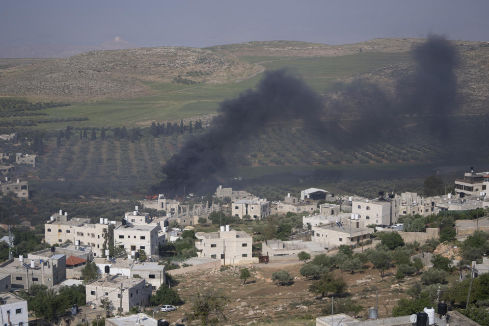 Smoke fills the sky after Israeli settlers set fire to the properties of Palestinian villagers in the West Bank village of al-Mughayyir, Saturday, April 13, 2024. Israel's army says the body of a missing Israeli teen has been found in the occupied West Bank after he was killed in a "terrorist attack." The disappearance of 14-year-old Binyamin Achimair sparked a large attack by settlers on the Palestinian village on Friday and Saturday. (AP Photo/Nasser Nasser)