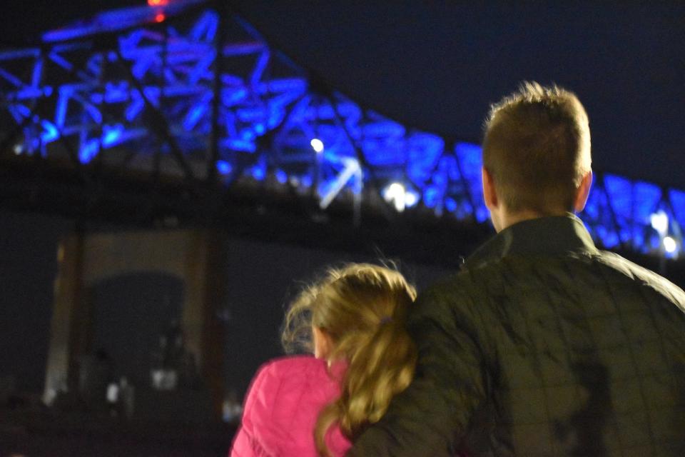 Shane Sousa, MassDOT district bridge engineer and daughter Olivia Sousa watch the lighting of the Braga Bridge in Fall River Tuesday.