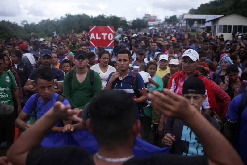 Migrants from Central American, part of a caravan travelling to the U.S., wait to cross into Mexico at the border between Guatemala and Mexico, in El Ceibo