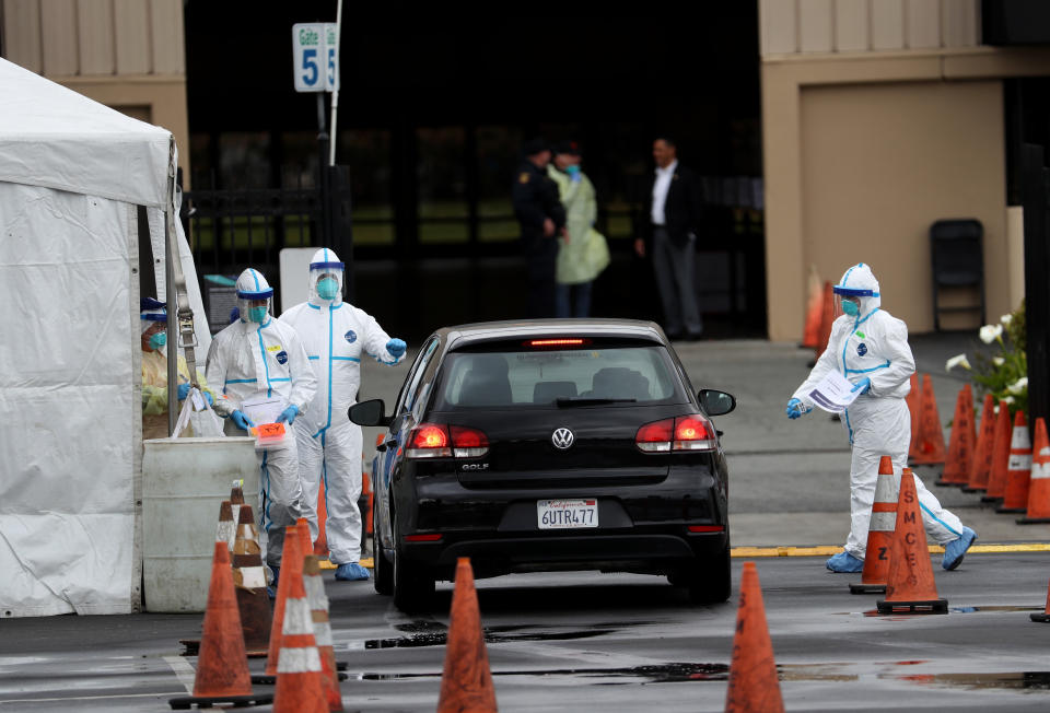 SAN MATEO, CALIFORNIA - MARCH 16: Medical personnel surround a car that is going through a coronavirus drive-thru test clinic at the  San Mateo County Event Center on March 16, 2020 in San Mateo, California. Drive-thru test clinics for COVID-19 are popping up across the country as more tests become available. (Photo by Justin Sullivan/Getty Images)