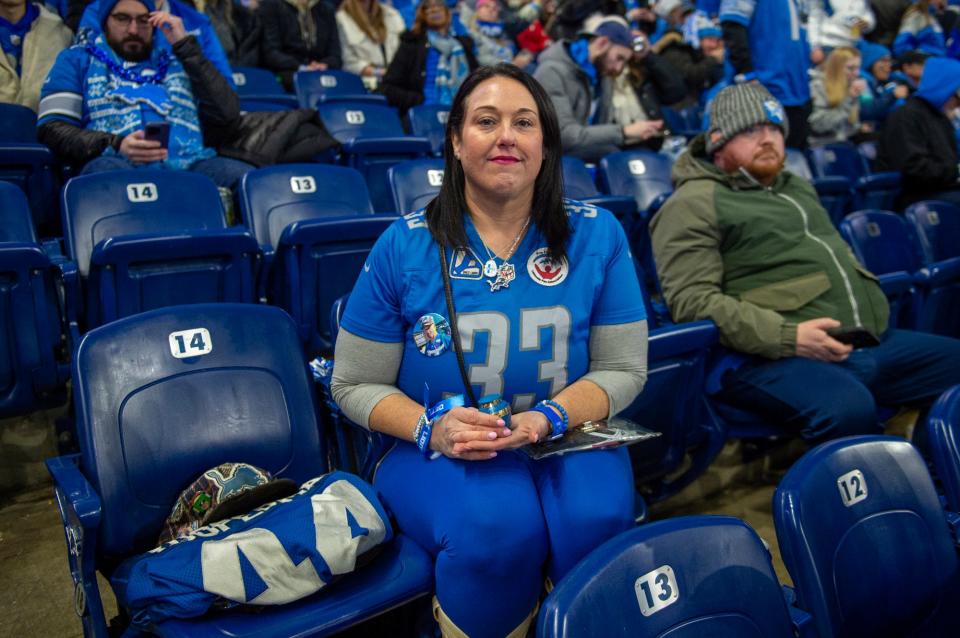 Megan Stefanski holds her father Donnie "Yooperman" Stefanski's ashes while sitting in the stands before the start of the game against the L.A. Rams at Ford Field on Sunday, Jan. 14, 2023.