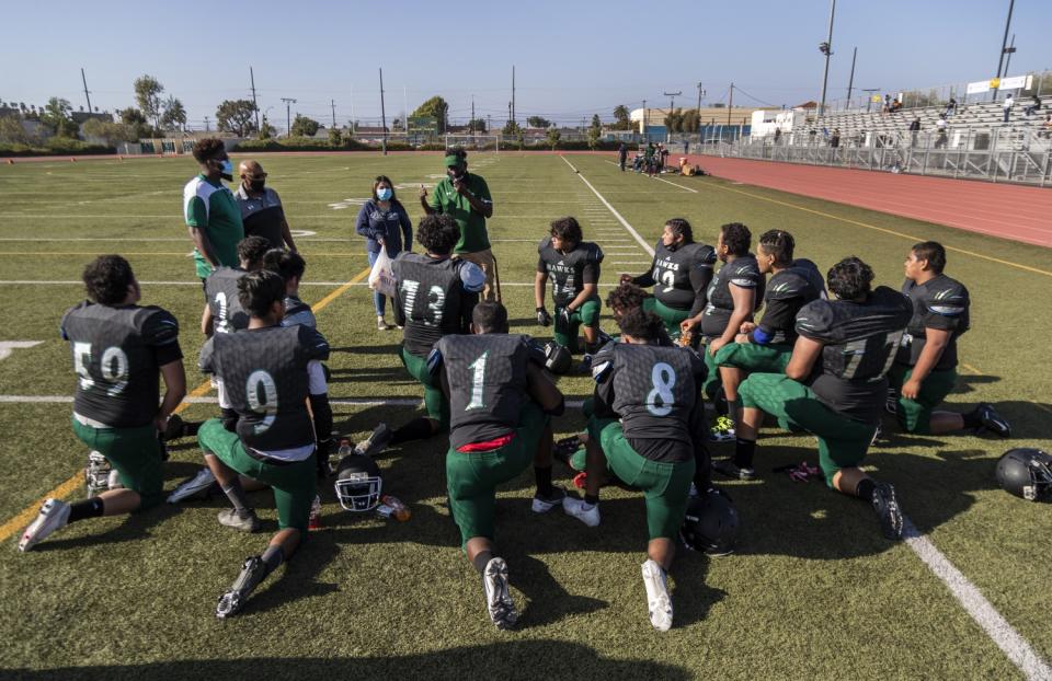 Hawkins coach Ronald Coltress talks to his team during halftime of their game against Manual Arts on April 9, 2021.