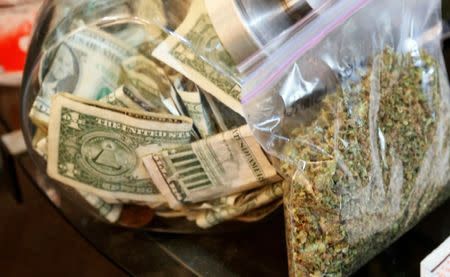 FILE PHOTO: A bag of marijuana being prepared for sale sits next to a money jar at BotanaCare in Northglenn, Colorado, U.S., December 31, 2013. REUTERS/Rick Wilking/File Photo