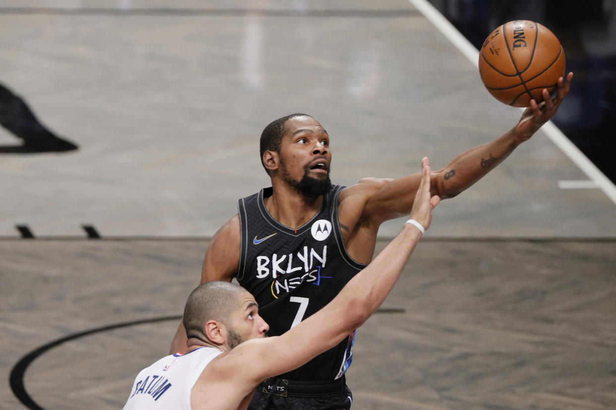 Kevin Durant gets his hand on the ball as Nicolas Batum stretches toward the ball.