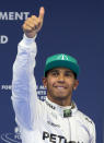 Mercedes driver Lewis Hamilton of Britain gestures to his fans after he won the pole position for Sunday's Chinese Formula One Grand Prix at Shanghai International Circuit in Shanghai, China Saturday, April 19, 2014. (AP Photo/Andy Wong)