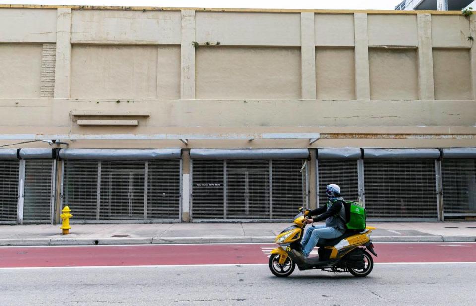 Un motociclista pasa por delante de los escaparates cerrados del multimillonario Moishe Mana en la Southeast First Street, en el downtown de Miami.
