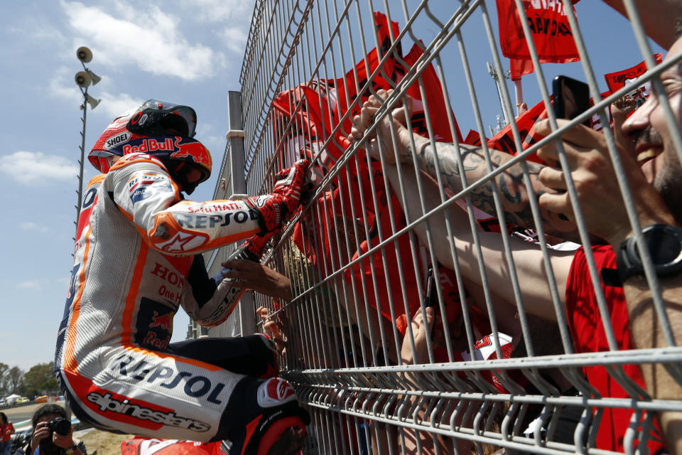 MotoGP rider Marc Marquez of Spain climbs on a fence to celebrate with the fans after winning the Spanish Motorcycle Grand Prix at the Angel Nieto racetrack in Jerez de la Frontera, Spain, Sunday, May 5, 2019. (AP Photo/Miguel Morenatti)