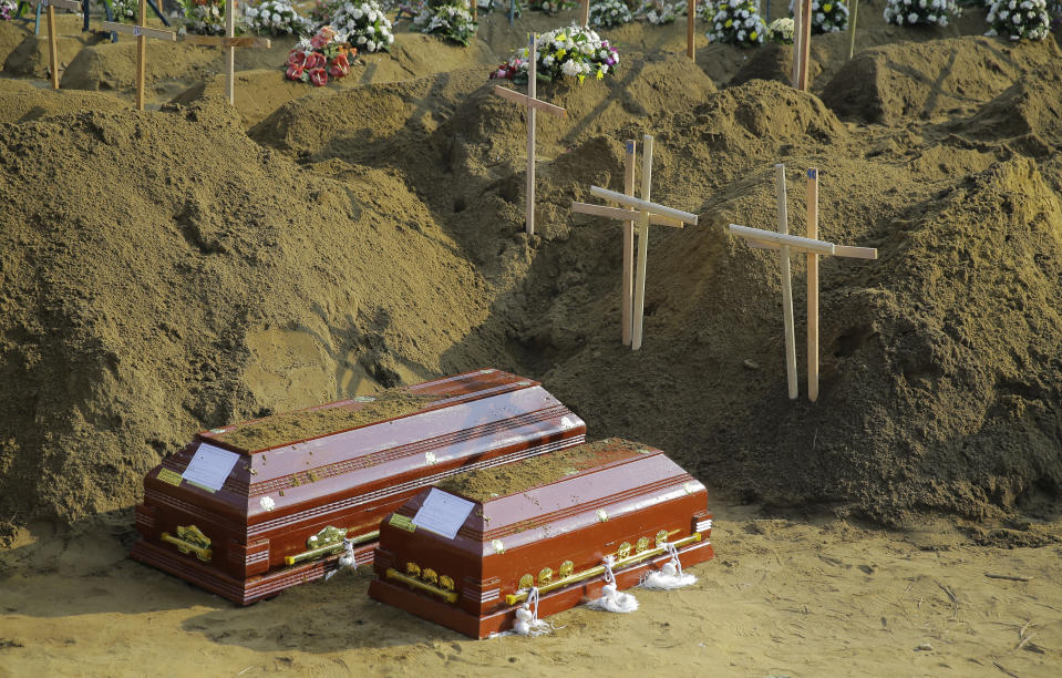 FILE - In this Wednesday, April 24, 2019 file photo, coffins of victims of Easter Sunday's bombing lay at a mass burial ground in Katuwapitiya village in Negombo, Sri Lanka. Roughly 250 people died in six coordinated suicide bombings that ripped through Sri Lanka on Easter Sunday. (AP Photo/Eranga Jayawardena, File)