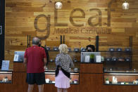 Customers brows medical cannabis products are on display at the Green Leaf Medical Cannabis dispensary in Richmond, Va., Thursday, June 17, 2021. The date for legalizing marijuana possession is drawing near in Virginia, and advocacy groups have been flooded with calls from people trying to understand exactly what becomes legal in July. (AP Photo/Steve Helber)