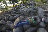 A man rests next the Suchiate River in Ciudad Hidalgo, on the Mexican border with Guatemala, Sunday, Jan. 19, 2020. Mexican authorities have closed a border entry point in southern Mexico after thousands of Central American migrants tried to push across a bridge between Mexico and Guatemala. (AP Photo / Marco Ugarte)