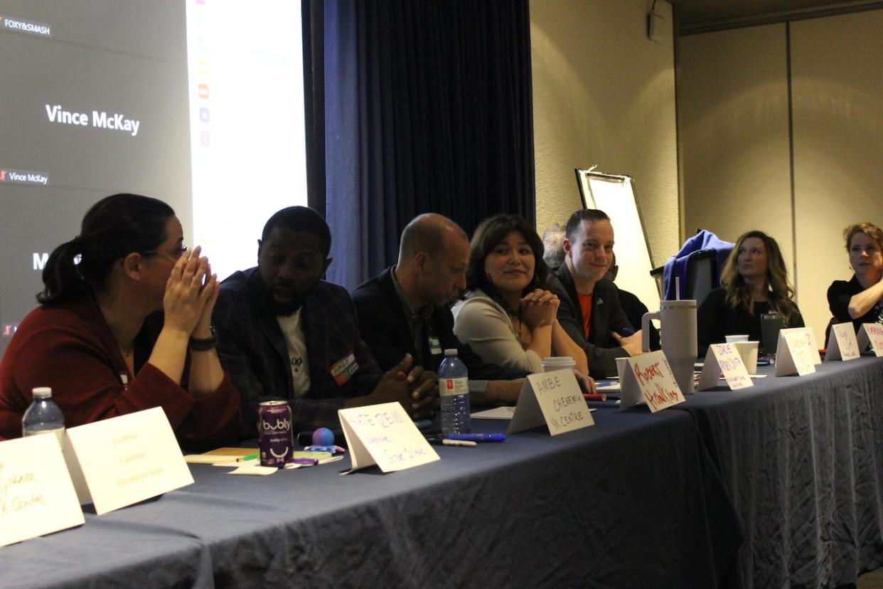 A little more than a third of the candidates in the N.W.T.'s 2023 territorial election participated in a debate at the Explorer Hotel on Monday evening. Visible from left to right are candidates Kate Reid, Ambe Chenemu, Robert Hawkins, Stacie Arden Smith, Keiron Testart, Nicole Sok and Katrina Nokleby. (Liny Lamberink/CBC - image credit)