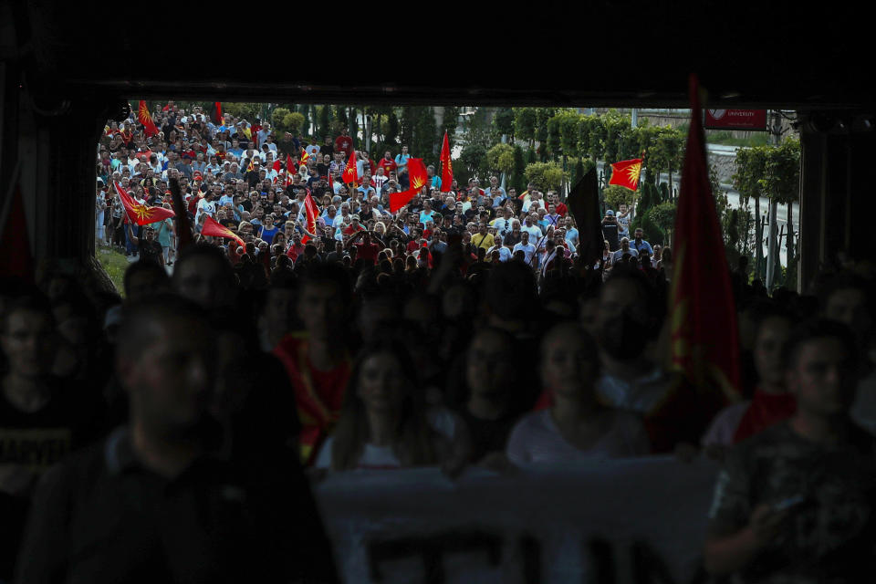 FILE - People enter a tunnel while marching through a street during a protest in Skopje, North Macedonia, Wednesday, July 6, 2022. Nightly protests in North Macedonia over the past week have left dozens injured. At the heart of the turmoil is the small Balkan country’s long-running quest to join the European Union, a process that has faced one hurdle after the other. (AP Photo/Boris Grdanoski, File)