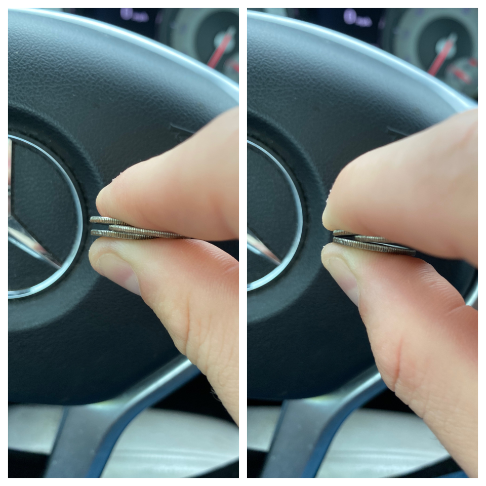 a person holding 3 dimes together, the one in the middle furthest in, making the other two pince together