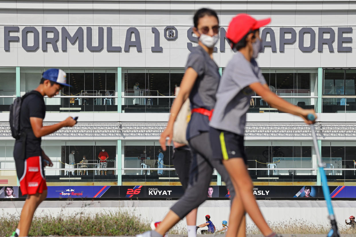 People walk past the Formula One Pit building, which was converted into a treatment facilities for seniors who are infected with COVID-19 on February 19, 2022 in Singapore. (Photo by Suhaimi Abdullah/NurPhoto via Getty Images)