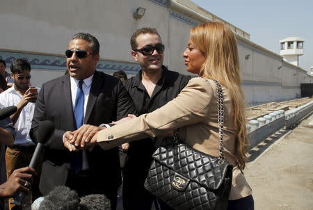 Al Jazeera television journalist Mohamed Fahmy (L) announces he got married to his fiance Marwa Omara next to journalist Baher Mohamed (C) as they talk to the media outside Tora prison, in Cairo, Egypt, July 30, 2015. REUTERS/Asmaa Waguih