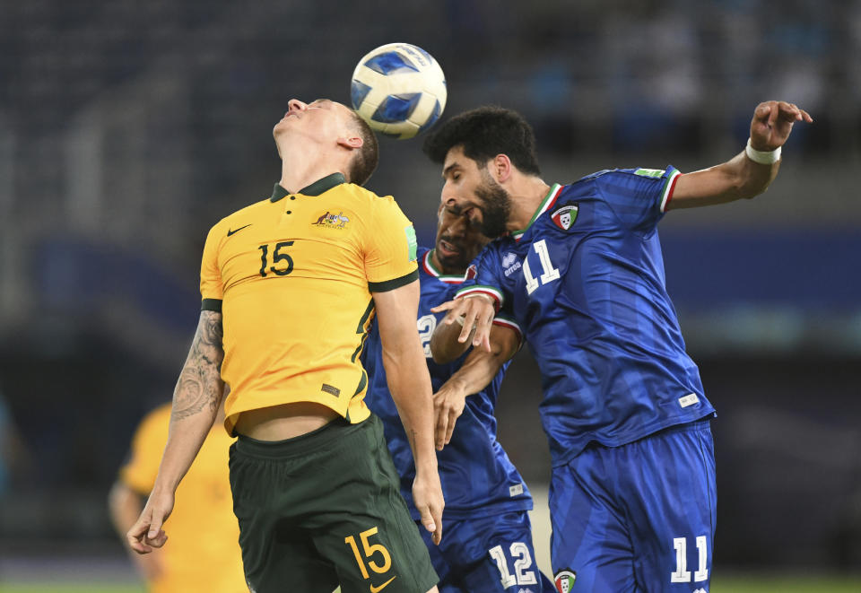 Australia's Mitchell Duke, left, jumps for the ball with Kuwait's Fahed Alansari, right, during the World Cup 2022 Group B qualifying soccer match between Kuwait and Australia in Kuwait City, Kuwait, Thursday, June 3, 2021. (AP Photo/Jaber Abdulkhaleg)