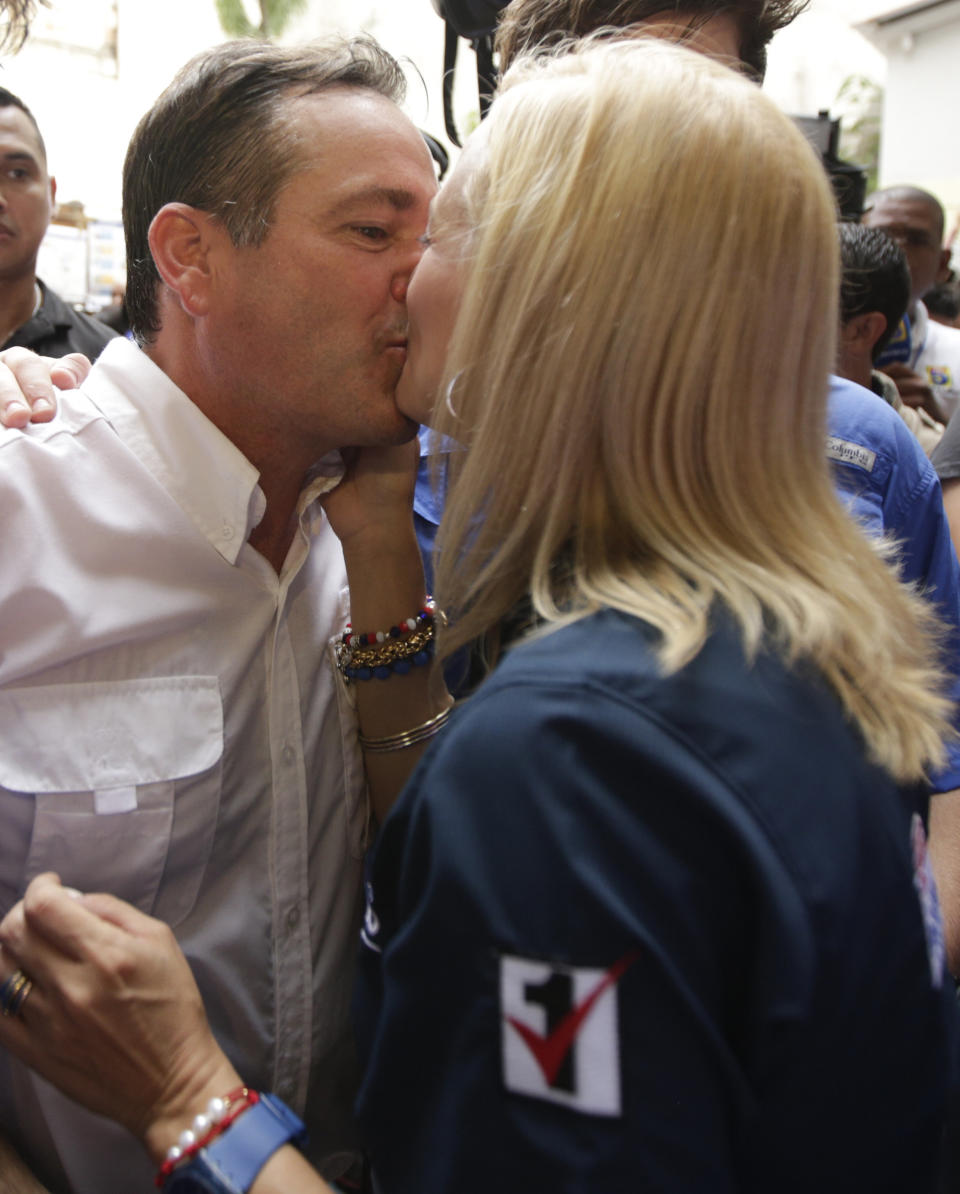 Juan Carlos Navarro, left, presidential candidate for the Democratic Revolutionary Party, kisses his wife Maria de los Angeles Campagnani after voting at a polling station in Panama City, Sunday, May 4, 2014. Panamanians are choosing President Ricardo Martinelli's successor in a three-way dogfight marked more by ugly personality clashes than any deep disagreements over the way forward for Latin America's standout economy. (AP Photo/Arnulfo Franco)